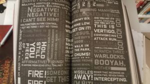 Black double page spread, with words in various orientations depicting frenetic confused battle radio messages. Type is in white and various shades of gray.